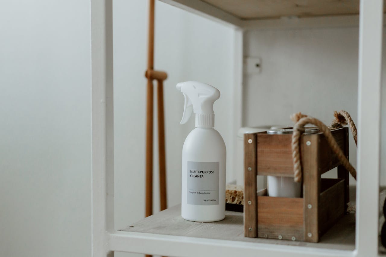 about-us Clean white shelf with a spray cleaner and wooden caddy, perfect for home organization.